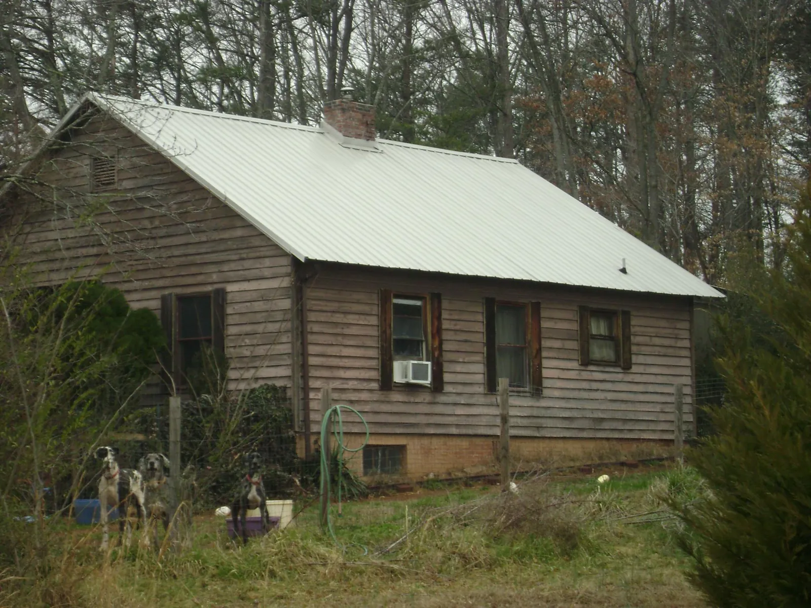 White metal roof on an old wood sided farmhouse, from a Metal Roof Installation job in Victor